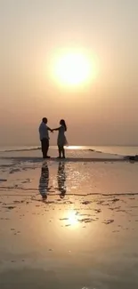 Silhouetted couple at sunset on a serene beach.