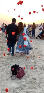 Couple walking on sandy beach with red hearts.