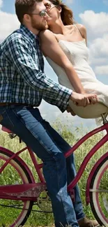 Couple on a bicycle under blue sky, sharing a romantic moment.