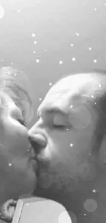 Romantic black and white couple kissing in grayscale image.