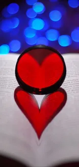 Red heart shadow on book pages with blue bokeh background.