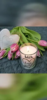 Romantic candle and tulips with heart decoration on gray background.