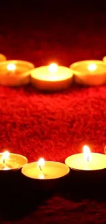 Heart-shaped candle arrangement on a red background