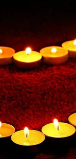 Heart shape formed by candles on a red background.