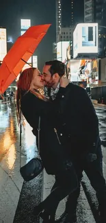 Couple kissing under orange umbrella in city night scene.