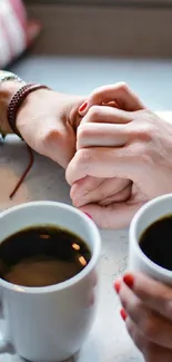 Romantic coffee date wallpaper with hands holding over coffee.