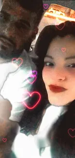 Romantic selfie of couple with neon hearts in a car at night.