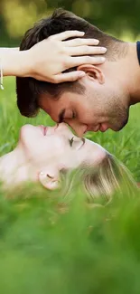 Couple laying in lush green field, sharing a romantic moment.