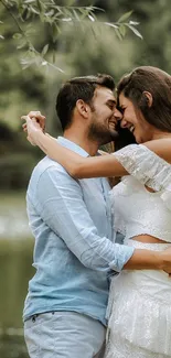 Romantic couple embracing in nature by a green lake.