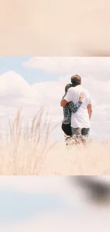 Couple embracing in a serene grassy field with clouds.