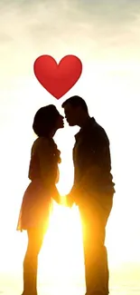 Romantic silhouette of a couple at sunset with a heart above.