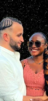 Smiling couple under a starry night sky, embracing warmly.