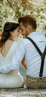 Romantic couple sitting under lush green trees.