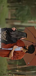 Romantic couple standing under a brown umbrella in a forest setting.