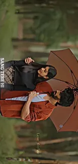 Romantic couple standing under umbrella in a forest setting.