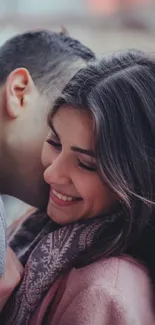 Couple sharing a warm embrace with festive lights in the background.