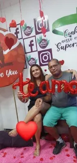 Couple in love with heart decorations and social media backdrop.