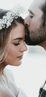 Romantic couple in close embrace with floral wreath.