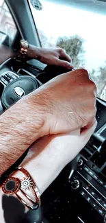 Couple holding hands in car, signifying romance and adventure.