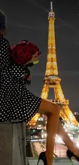 Woman holding roses near Eiffel Tower at night.