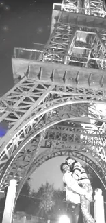 Couple under the Eiffel Tower at night with a starry sky.