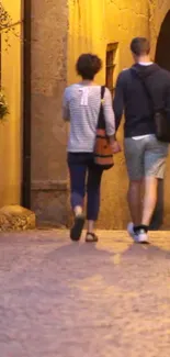 Couple walking through an evening-lit cobblestone street.