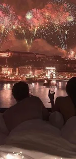 Couple enjoying fireworks display over city skyline at night.