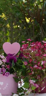 Mobile wallpaper with pink flowers and heart decoration on greens.