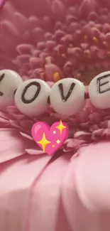 Pink gerbera flower with 'LOVE' beads and heart design.