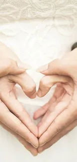 Hands forming a heart in romantic wallpaper.