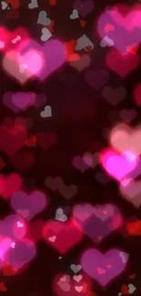 Mobile wallpaper with heart-shaped bokeh in pink and red hues.