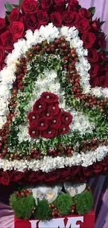 Heart-shaped floral arrangement with red roses and white blooms.