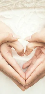 Romantic hands forming a heart shape on a soft cream background.