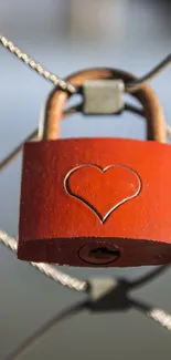 Red heart lock on metal chain, perfect for romantic wallpaper.