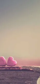 Two pink hearts on a rustic book with a beige background.