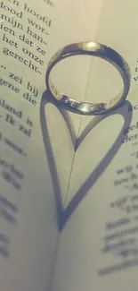 Ring creating heart shadow on book page.