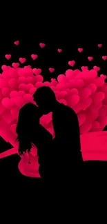 Romantic silhouette of a couple with pink hearts on a black background.