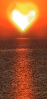 Romantic sunset with heart shape over ocean, vibrant orange hues.