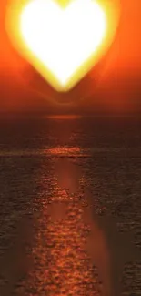 Heart-shaped sunset reflecting on ocean water with vibrant orange glow.