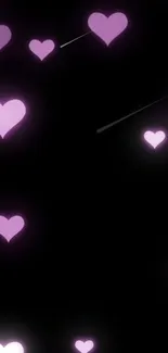 Glowing pink hearts on black wallpaper.