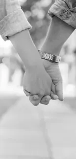 Black and white image of a couple holding hands.