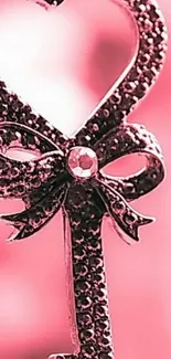 Romantic key with pink background, featuring heart shape and decorative bow.