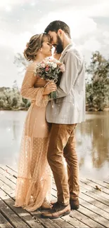 Romantic couple embracing by lake with flowers in hand.