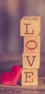 Wooden blocks spelling 'LOVE' with a red heart on warm beige background.