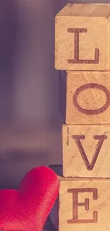 Wooden blocks spelling LOVE with a red heart.