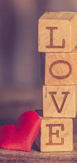 Wooden blocks spelling LOVE with a red heart.