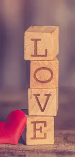 Wallpaper with wooden blocks spelling LOVE and a red heart.