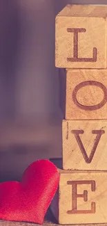 Wooden blocks spell LOVE with a red heart on rustic backdrop.