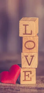 Wooden blocks spelling love with red heart.