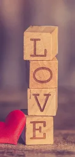 Wooden blocks spelling LOVE with a red heart.